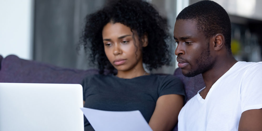 Two people looking worried as they read energy bill