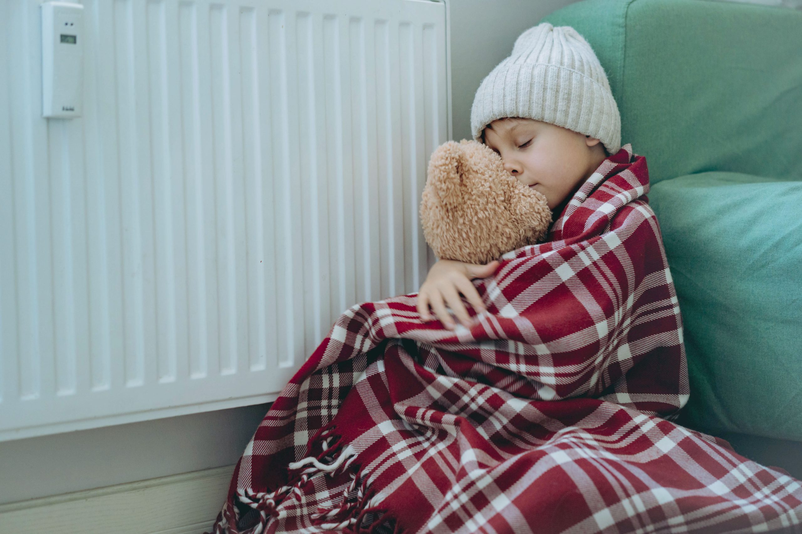 Child in fuel poverty by a radiator