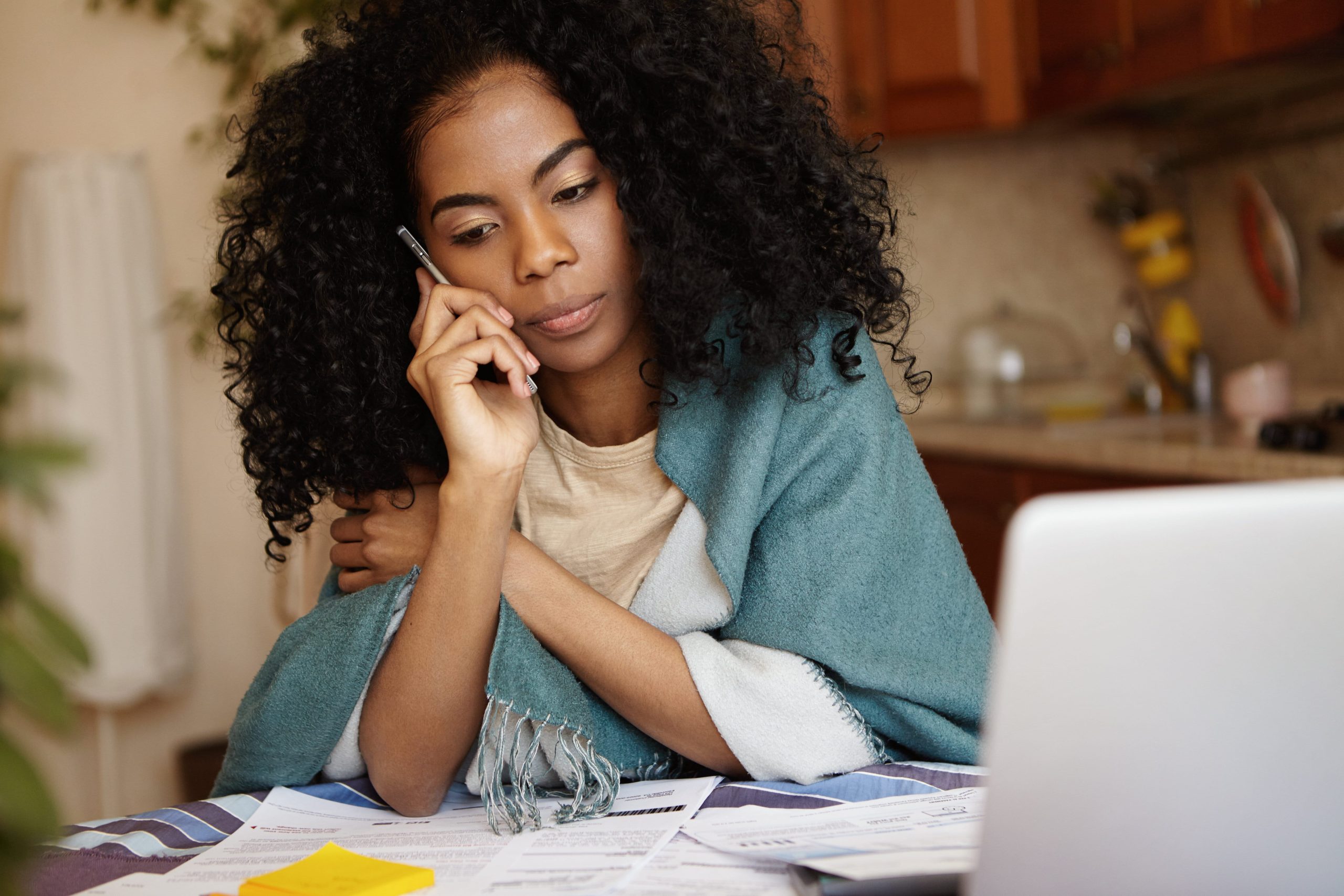Woman on phone, while wrapped in a blanket