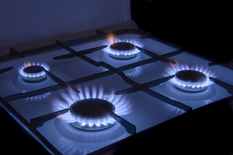 Image of a gas cooker. All four rings are on, showing blue gas flames