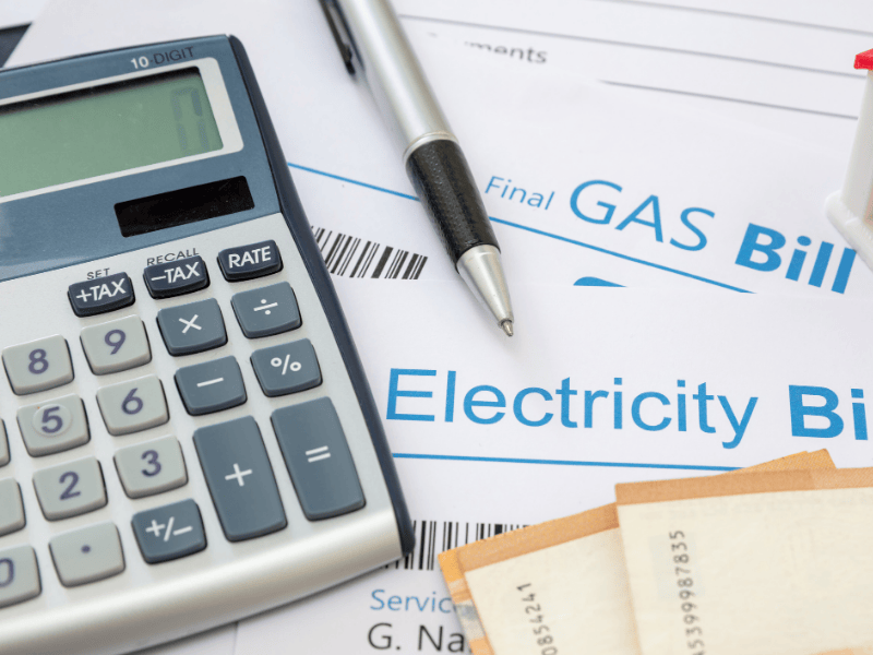 Photo of a gas bill, an electricity bill, a calculator and a pen.