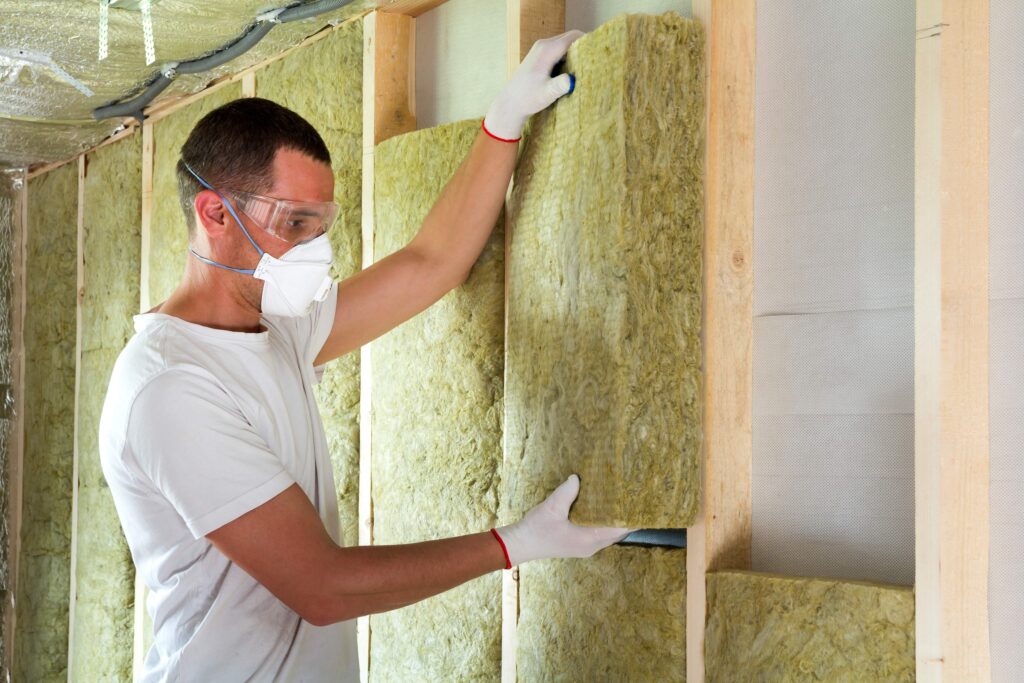 A photo of an installer installing internal wall insulation. 